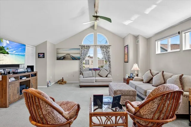 a living room with furniture a chandelier and a flat screen tv