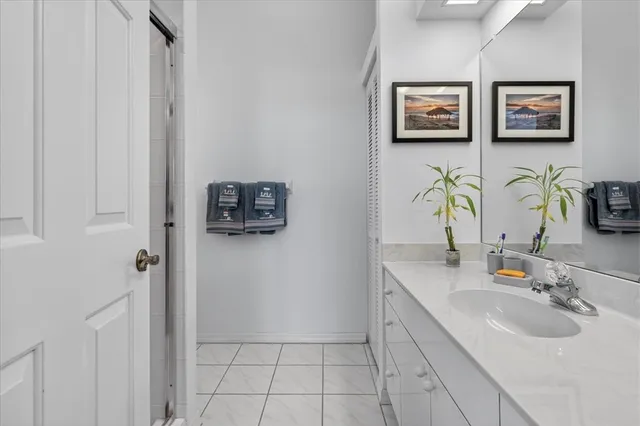 a bathroom with a sink a mirror and painting on the wall