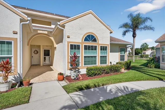 a view of a white house with a large windows and a yard