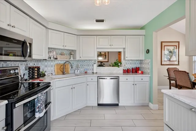 a kitchen with cabinets and steel appliances