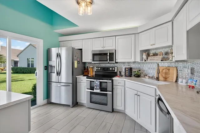 a kitchen with a sink a microwave a refrigerator and cabinets