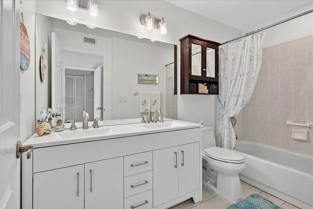 a bathroom with a sink a toilet and a large mirror