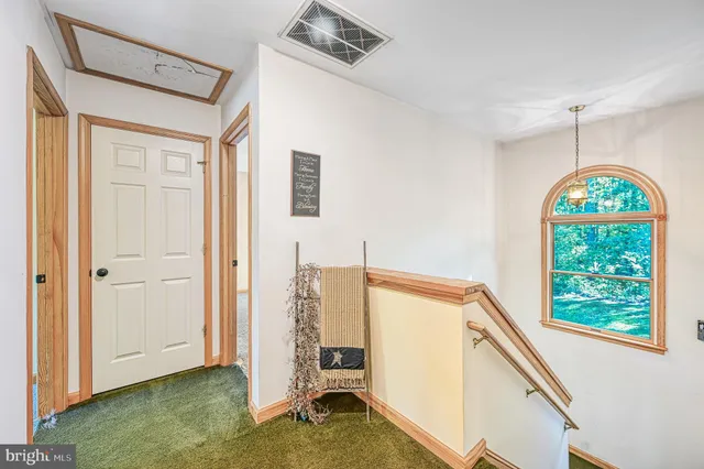 a view of a hallway with entryway wooden floor and windows