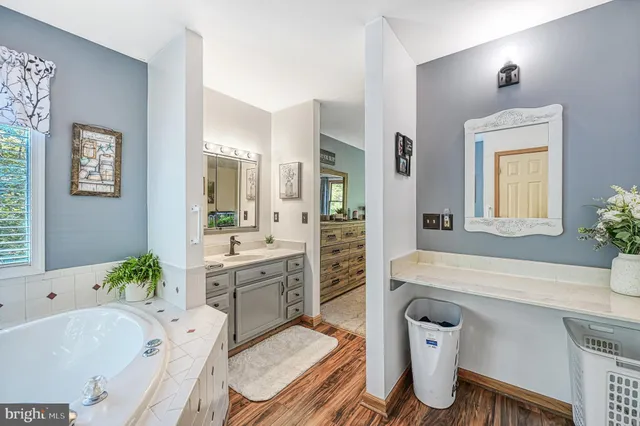 a spacious bathroom with a granite countertop tub sink and mirror