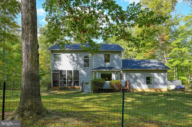 a view of a house with a backyard porch and a large tree