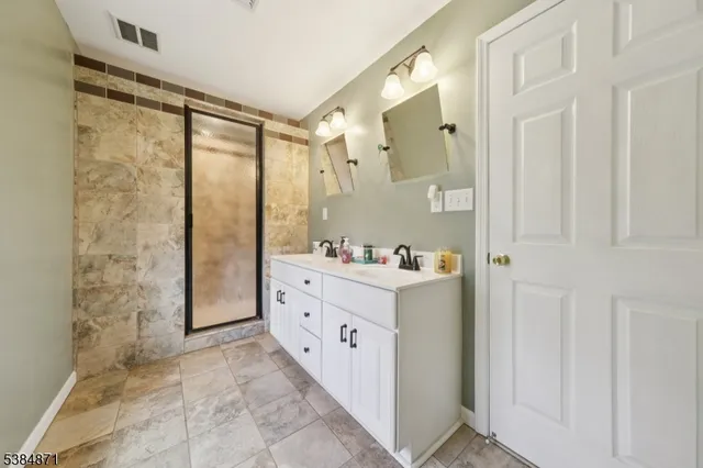 a bathroom with a granite countertop toilet sink mirror and vanity