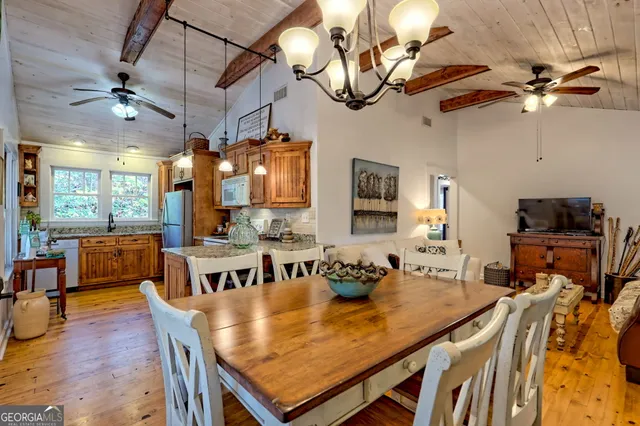 a view of a dining room with furniture a chandelier and wooden floor
