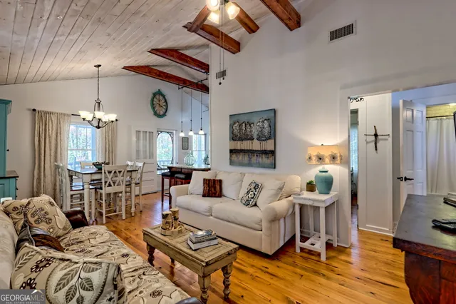 a living room with furniture a large window and a chandelier