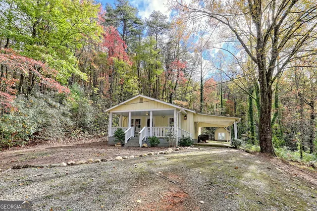 a front view of a house with a garden and trees