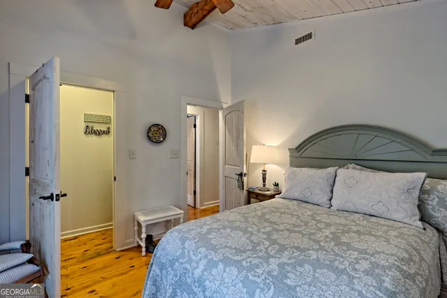 a bedroom with a bed and wooden floor