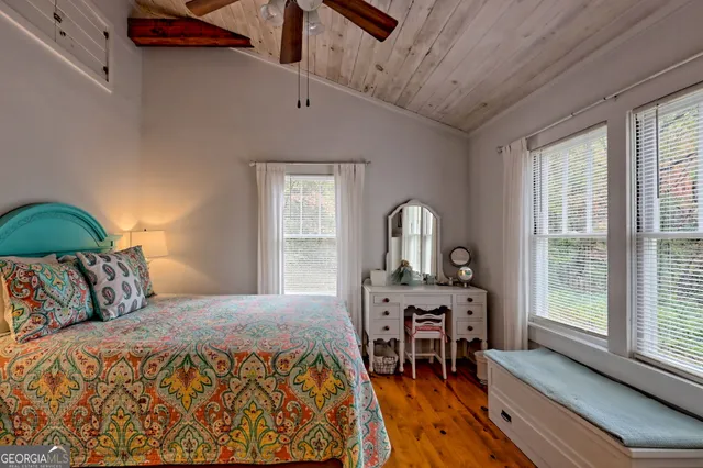a bedroom with a bed a table and a large window