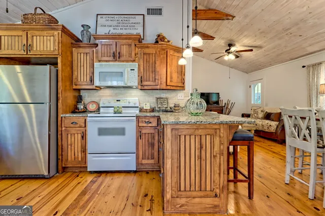 a kitchen with stainless steel appliances granite countertop a refrigerator and a stove top oven