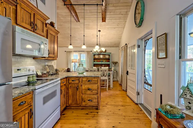a kitchen with stainless steel appliances granite countertop lots of counter top space and wooden floor