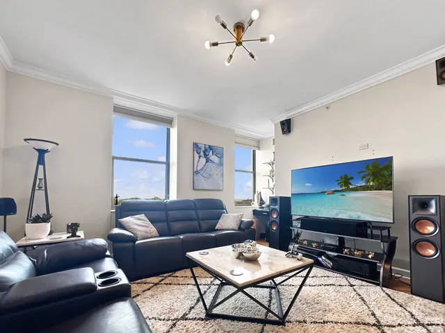 a living room with furniture a flat screen tv and a window