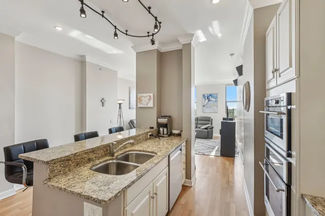 a kitchen with granite countertop a sink a counter top space a refrigerator and cabinets
