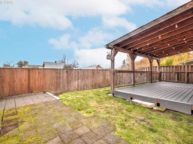 a view of backyard with wooden fence