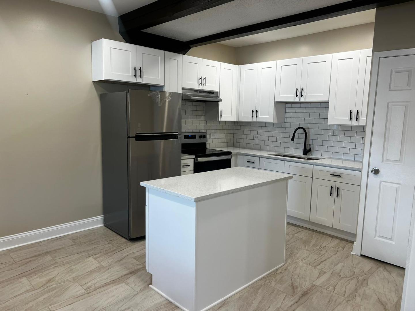 10102 Main Street, Unit 1A Hebron, IL 60034 - Photo 14 of 18 a kitchen with a sink a stove a refrigerator and cabinets