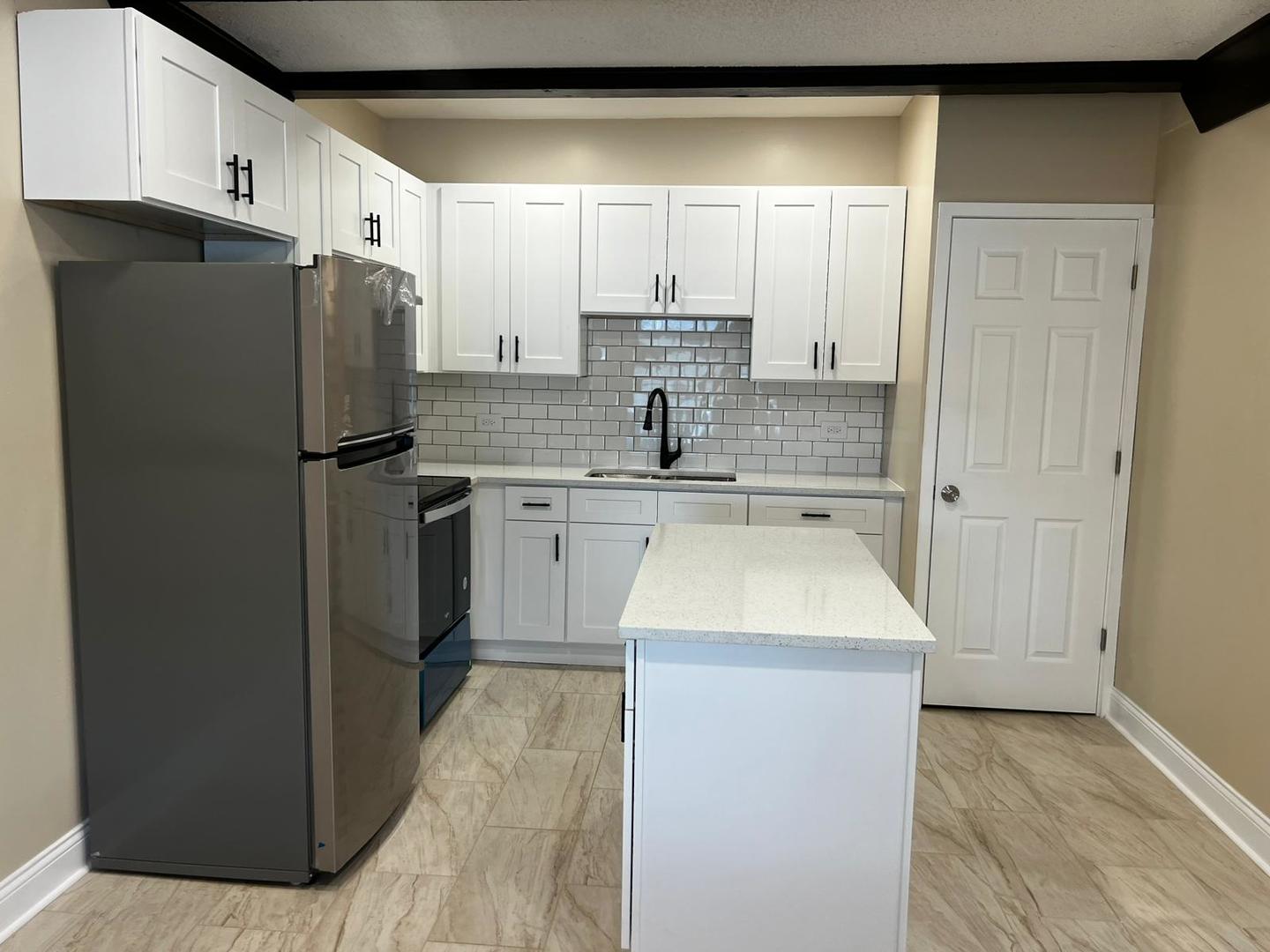 10102 Main Street, Unit 1A Hebron, IL 60034 - Photo 7 of 18 a kitchen with a sink a refrigerator and a stove