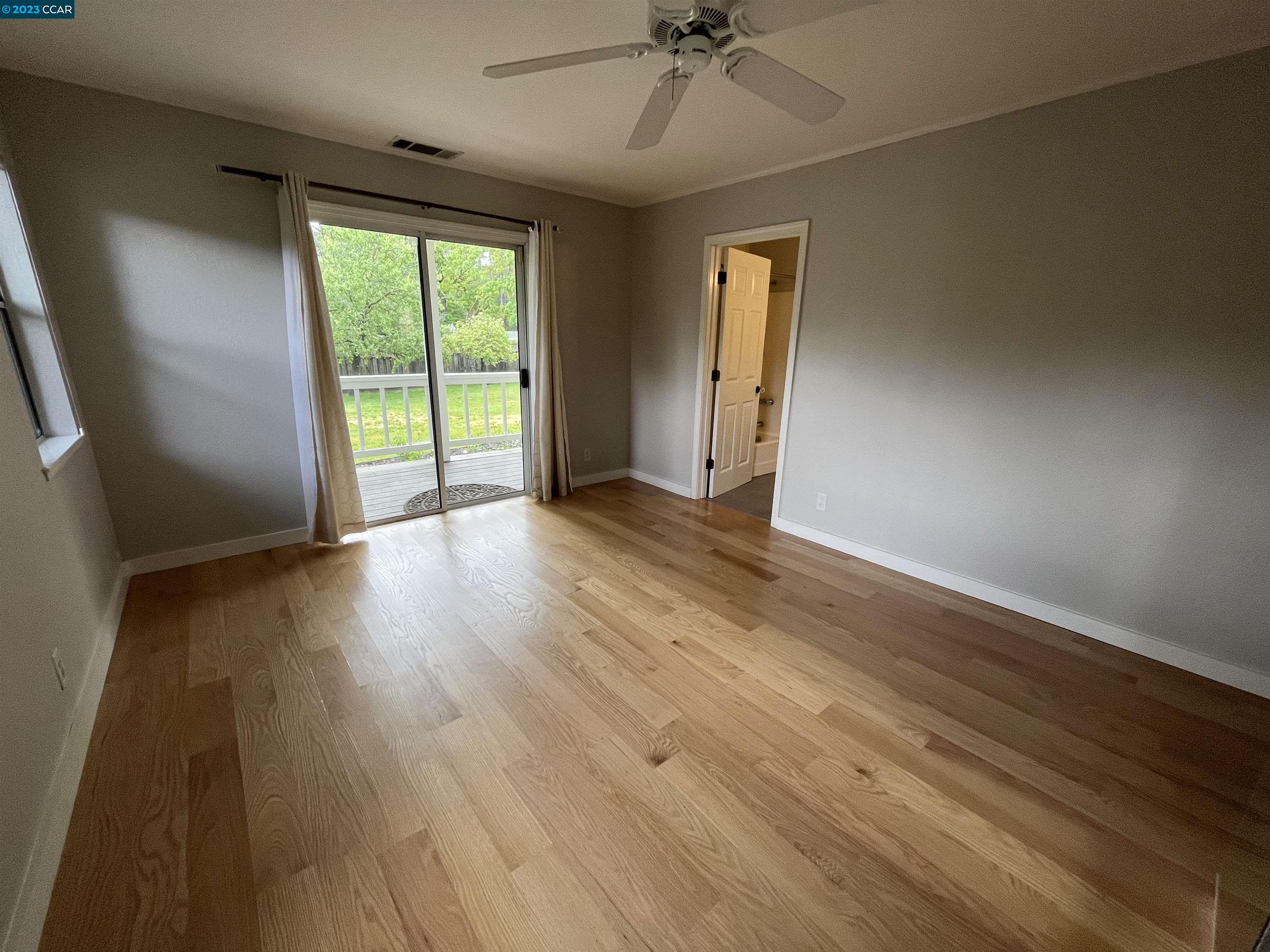 3524 Oliver Court Lafayette, CA 94549 - Photo 15 of 32 an empty room with wooden floor fan and windows