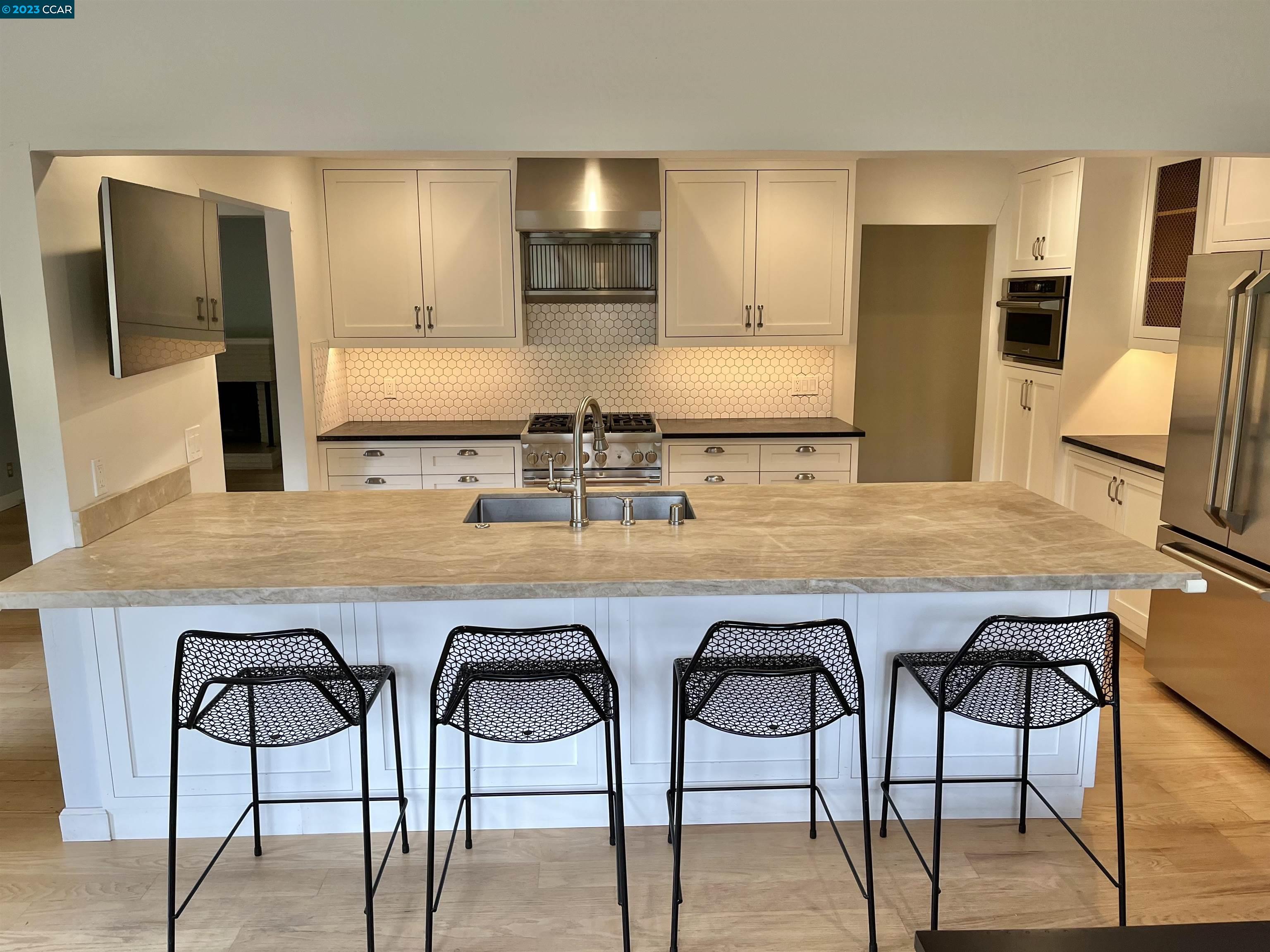3524 Oliver Court Lafayette, CA 94549 - Photo 7 of 32 a kitchen with stainless steel appliances kitchen island granite countertop a table chairs sink and refrigerator