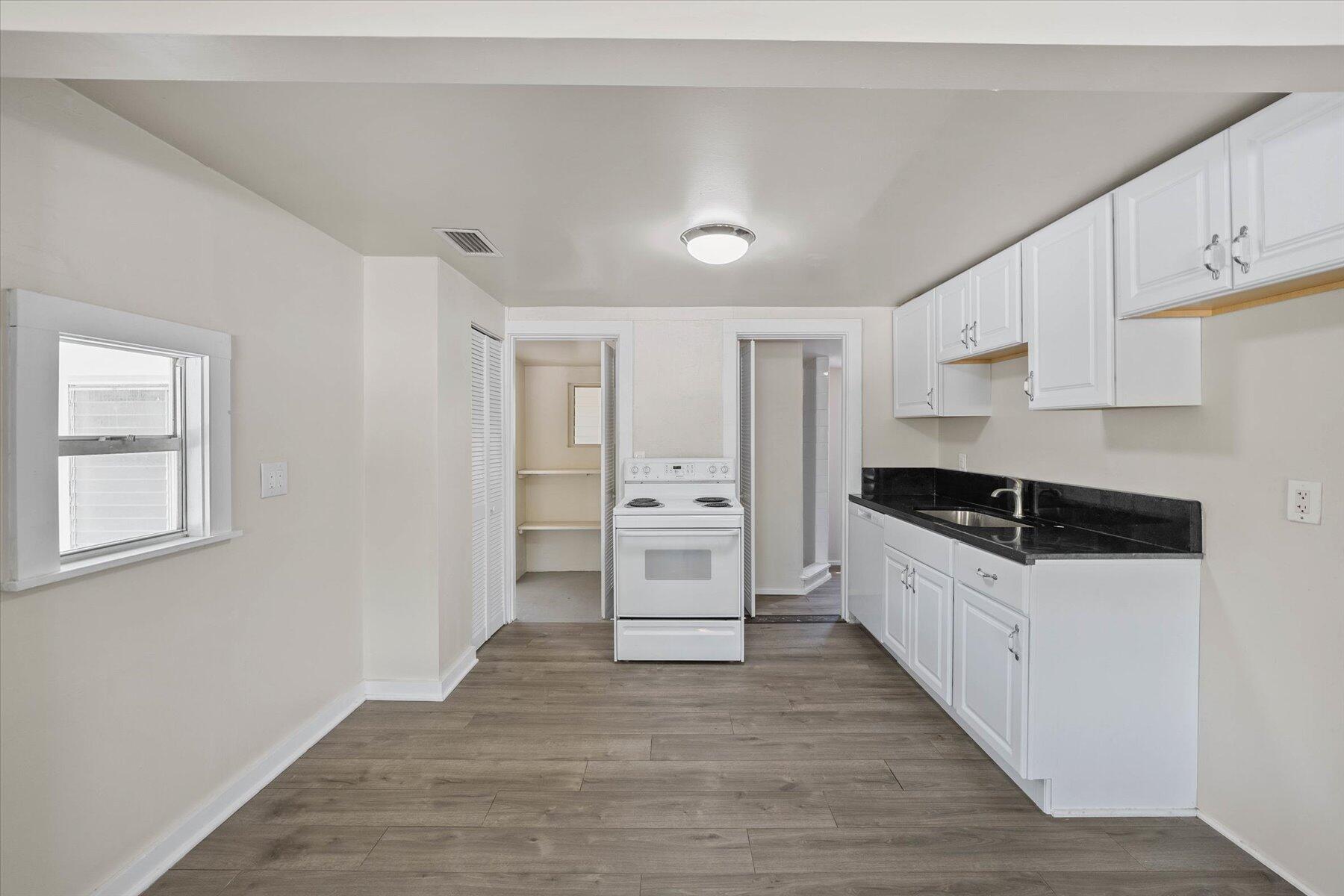 7936 Terrace Road Lantana, FL 33462 - Photo 12 of 25 a large white kitchen with granite countertop a large counter top space a sink stainless steel appliances and cabinets