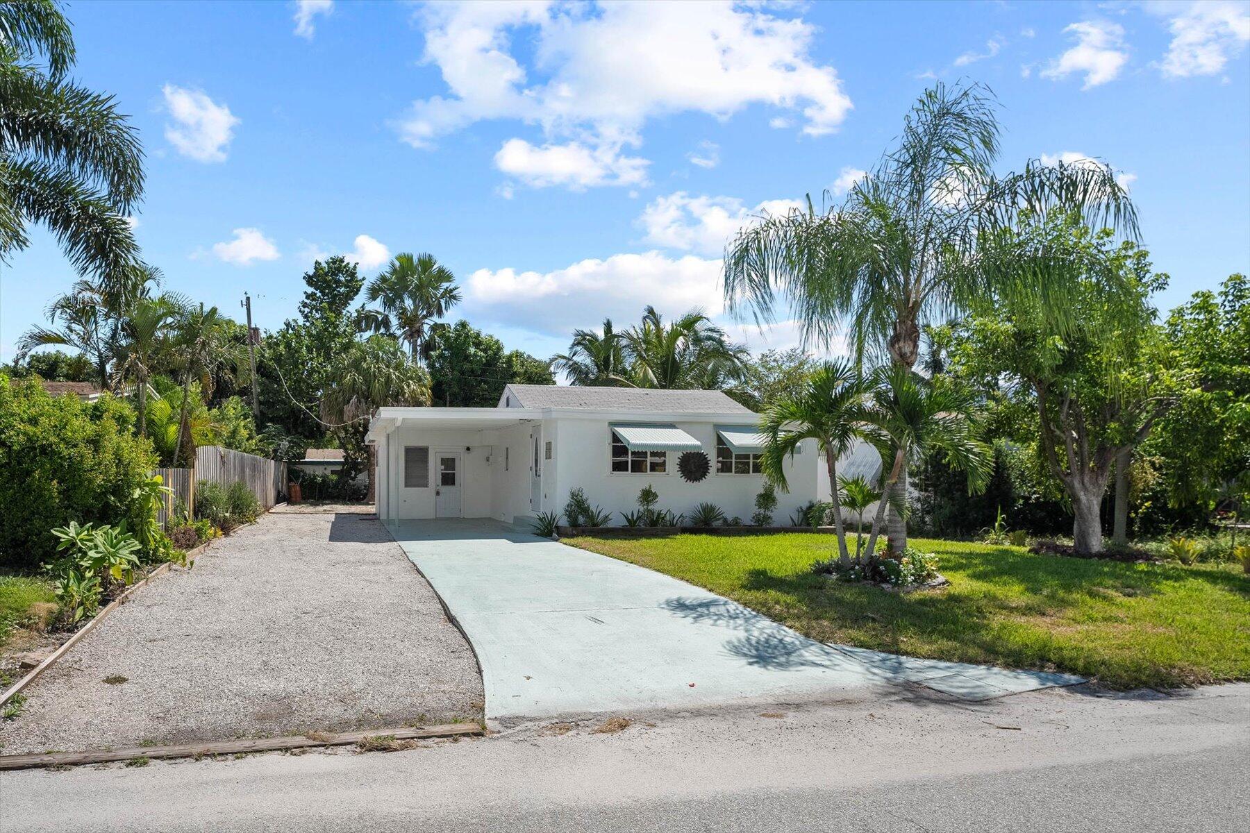 7936 Terrace Road Lantana, FL 33462 - Photo 3 of 25 a front view of a house with a yard and garage