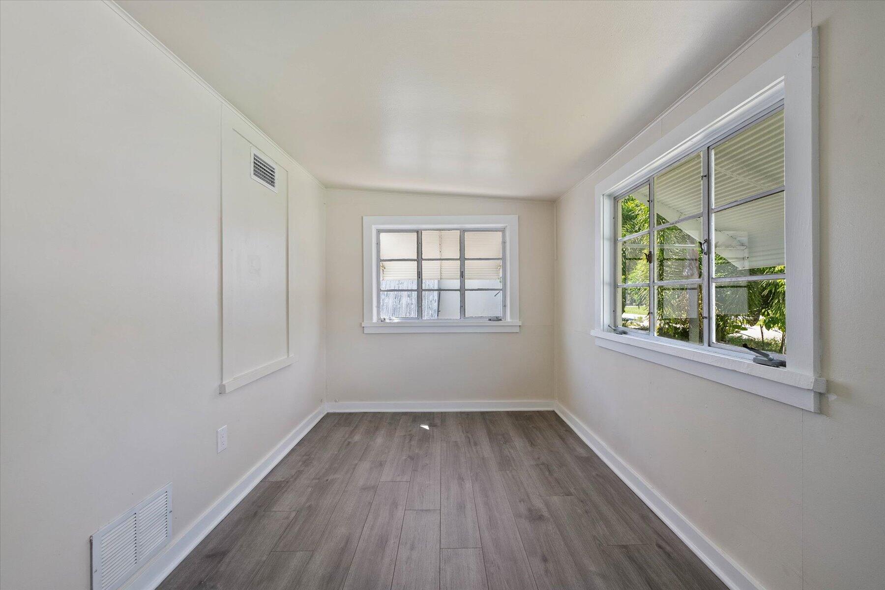 7936 Terrace Road Lantana, FL 33462 - Photo 7 of 25 an empty room with wooden floor and windows