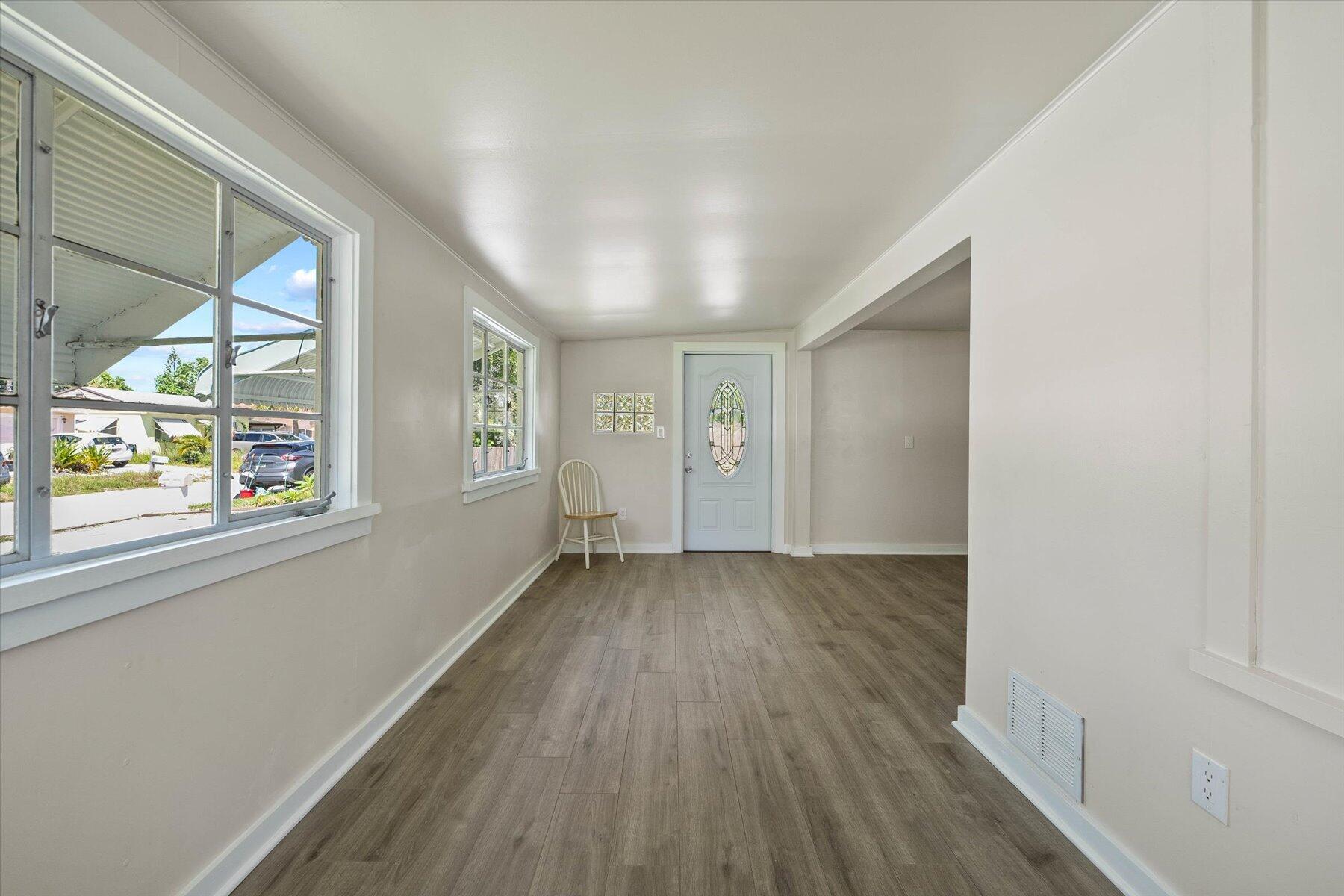7936 Terrace Road Lantana, FL 33462 - Photo 9 of 25 a view of an empty room with wooden floor and a window