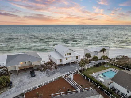 an aerial view of residential houses with outdoor space and ocean view