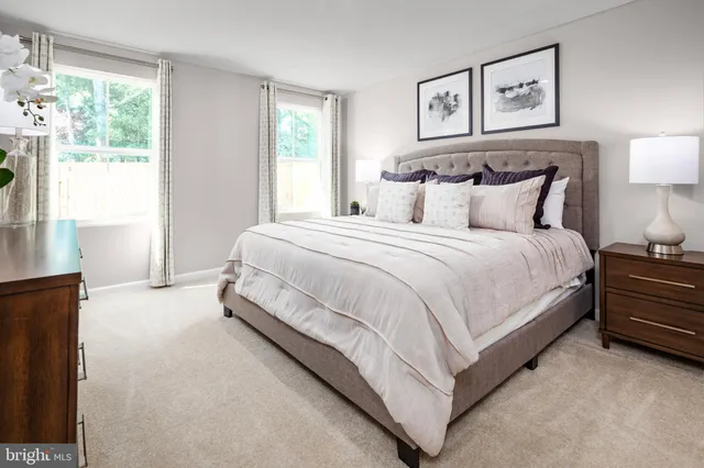 a large bed sitting in a bedroom next to a window