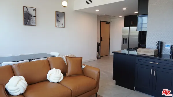 a living room with furniture kitchen view and a large mirror