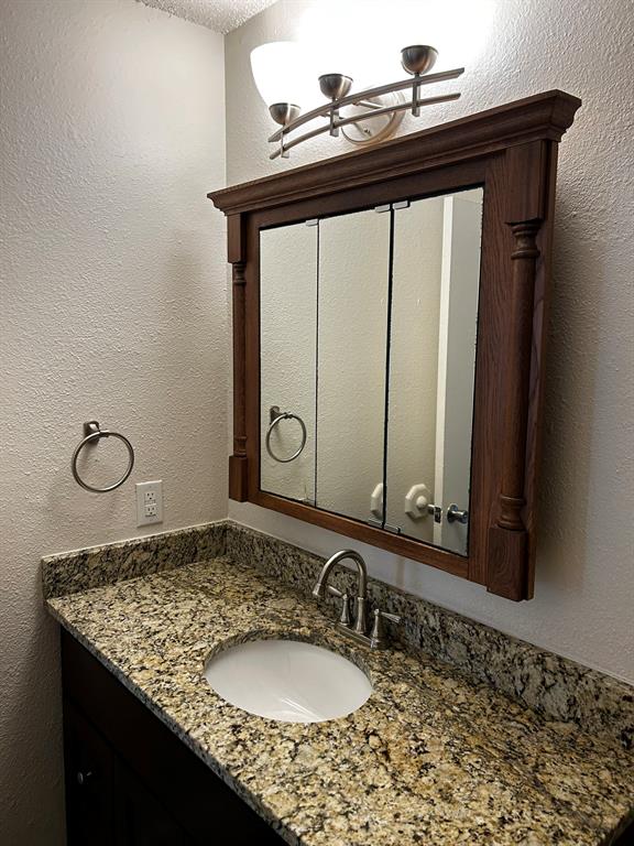 2200 East Trinity Mills Road, Unit 301 Carrollton, TX 75006 - Photo 12 of 16 a bathroom with a granite countertop sink and a mirror