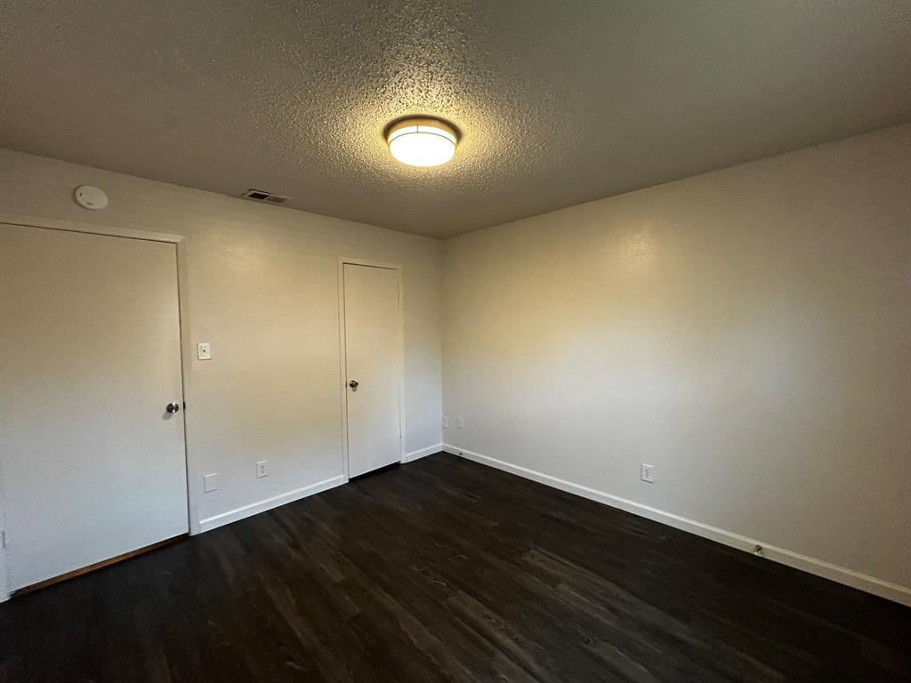 2200 East Trinity Mills Road, Unit 301 Carrollton, TX 75006 - Photo 14 of 16 an empty room with wooden floor and windows