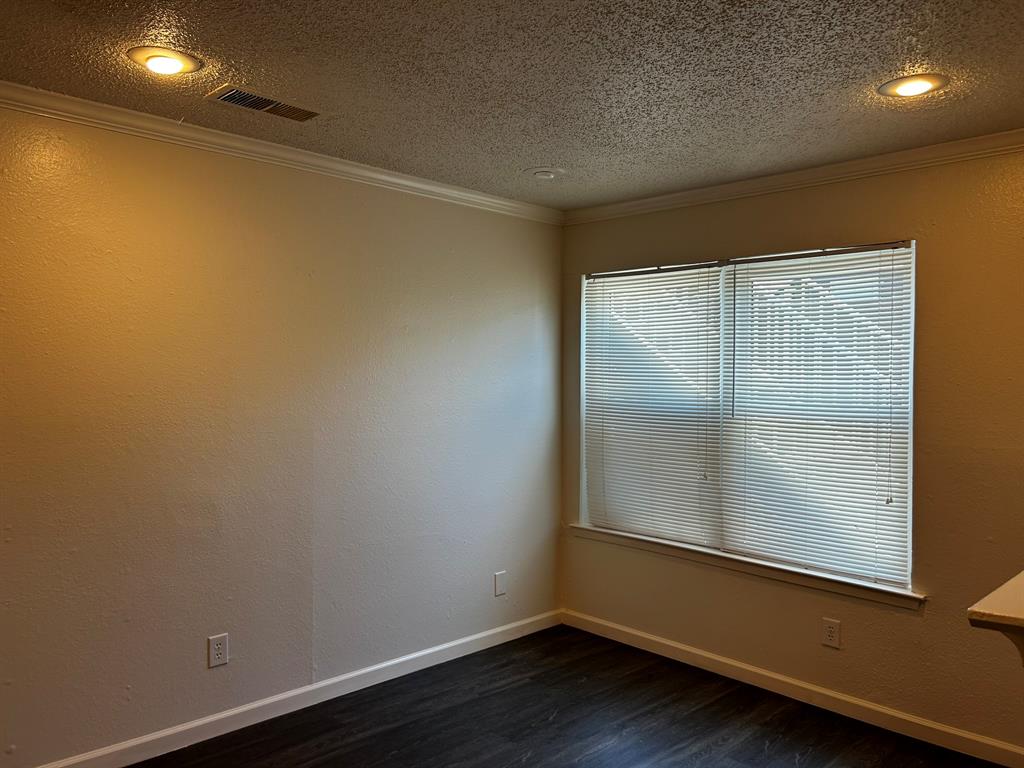 2200 East Trinity Mills Road, Unit 301 Carrollton, TX 75006 - Photo 4 of 16 an empty room with wooden floor and windows