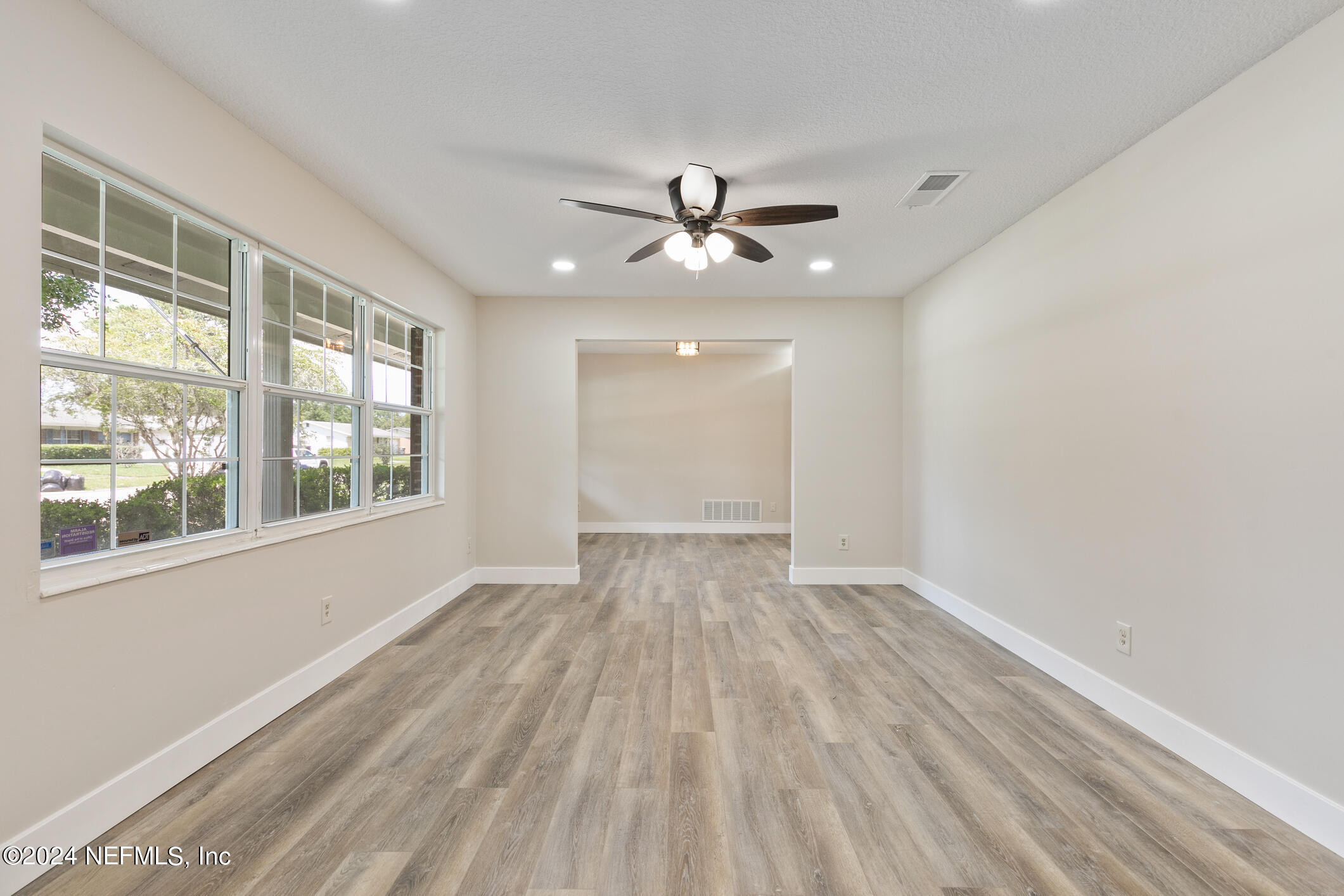 5984 Chevy Drive Jacksonville, FL 32216 - Photo 3 of 28 a view of empty room with wooden floor and fan