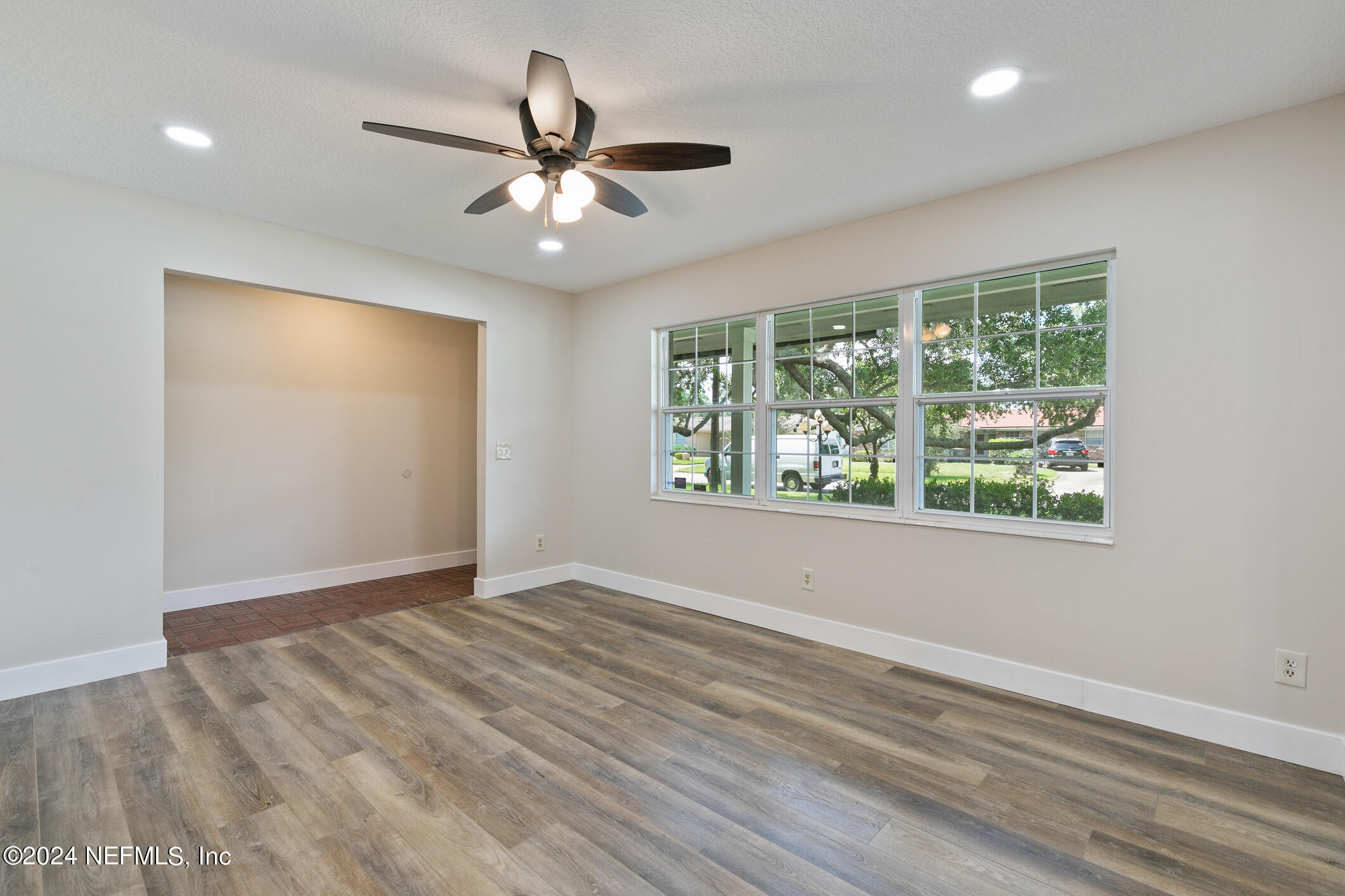 5984 Chevy Drive Jacksonville, FL 32216 - Photo 5 of 28 a view of an empty room with wooden floor and a window