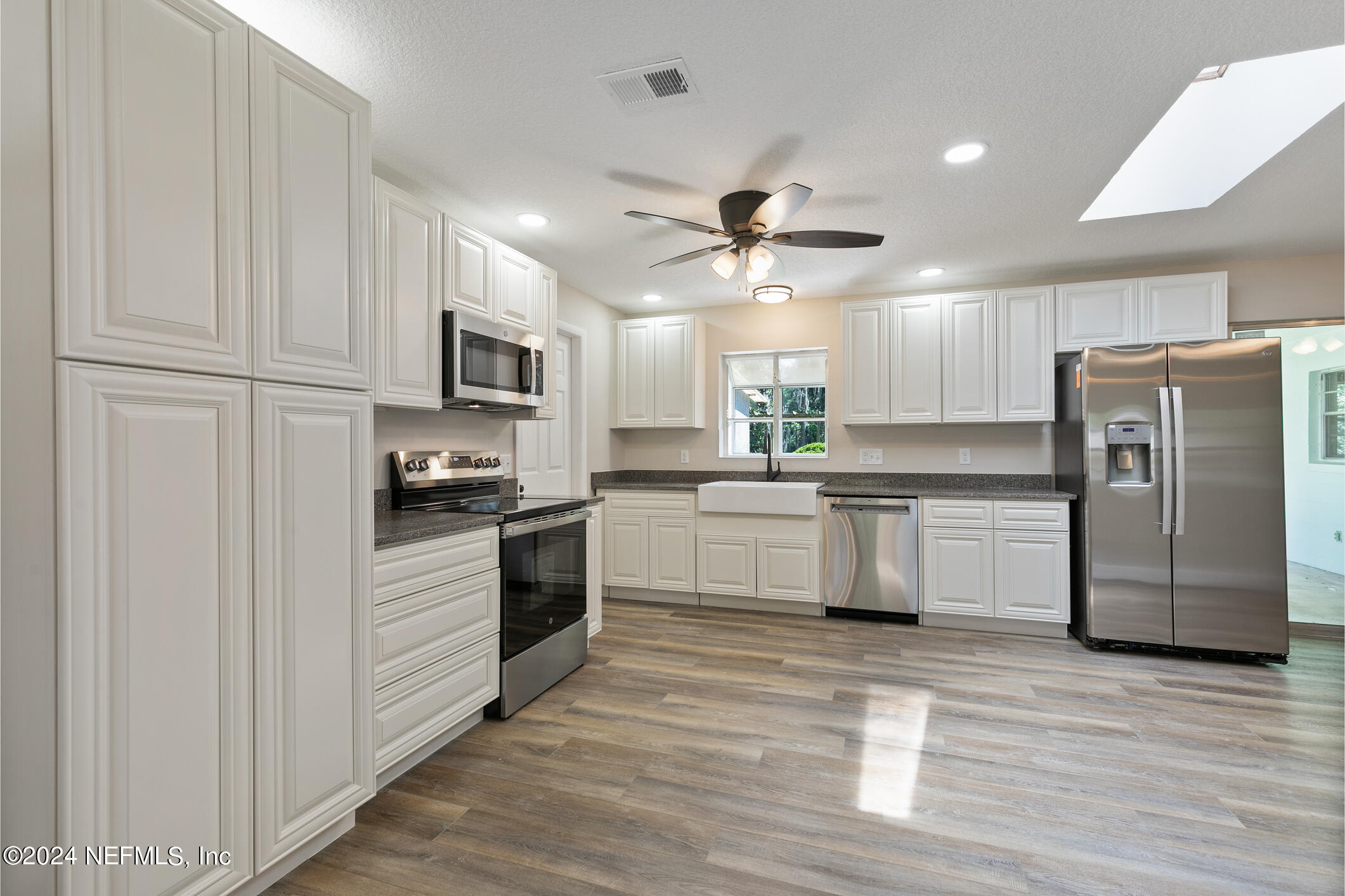 5984 Chevy Drive Jacksonville, FL 32216 - Photo 7 of 28 a kitchen with white cabinets and stainless steel appliances