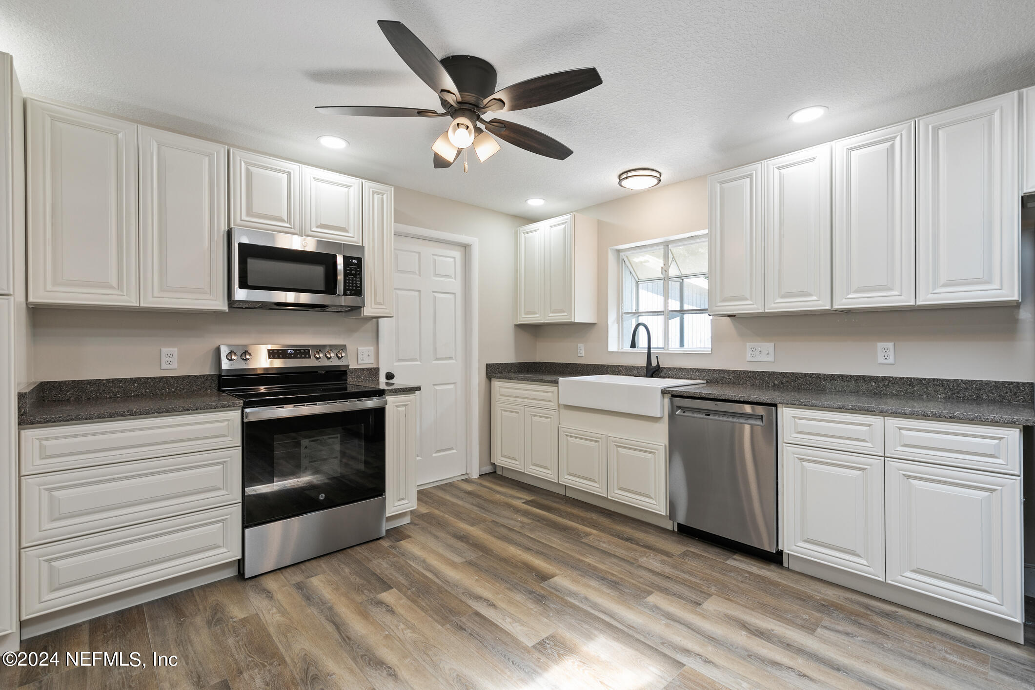 5984 Chevy Drive Jacksonville, FL 32216 - Photo 8 of 28 a kitchen with granite countertop a refrigerator a sink and dishwasher a stove top oven with wooden floor