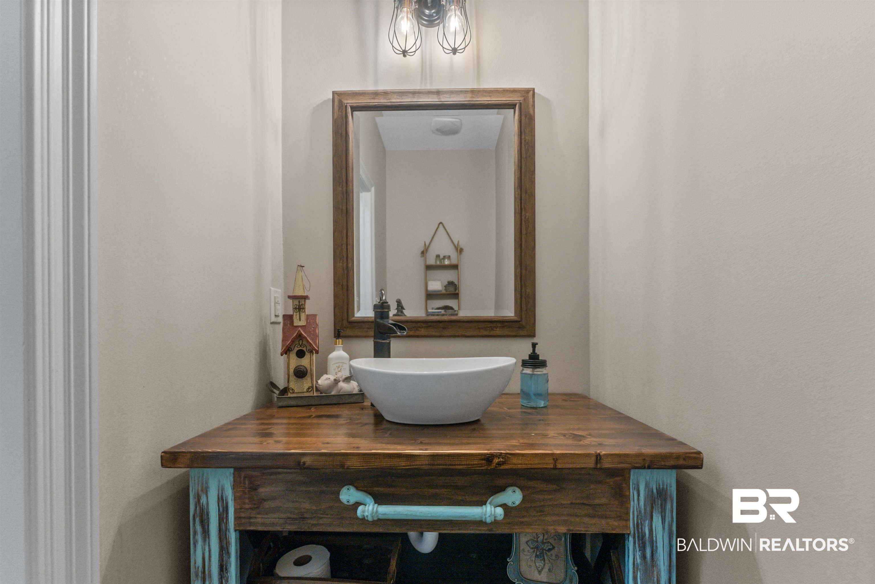 12070 Comalander Road Fairhope, AL 36532 - Photo 17 of 50 Custom wood vanity with a white vessel sink and dark bronze faucet
