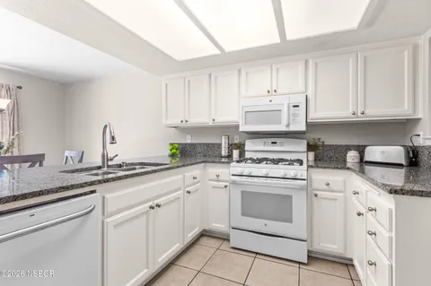 a kitchen with cabinets appliances a sink and a counter