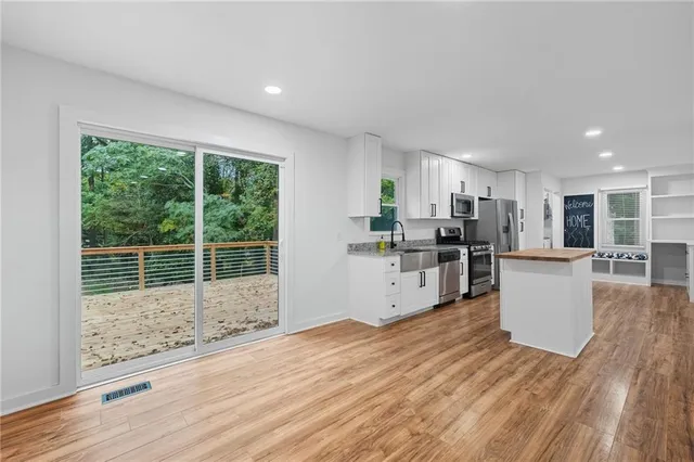 a kitchen with stainless steel appliances a refrigerator and wooden floor