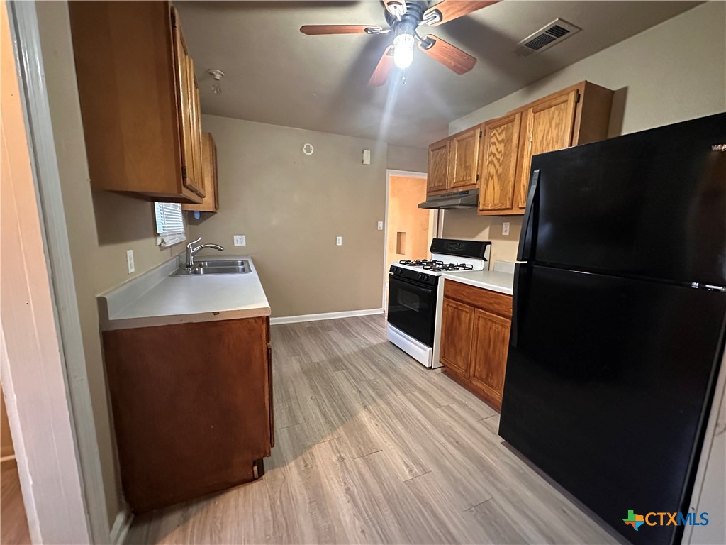 505 Center Street Belton, TX 76513 - Photo 2 of 11 a kitchen with a sink appliances and cabinets