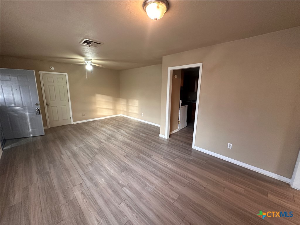 505 Center Street Belton, TX 76513 - Photo 5 of 11 an empty room with wooden floor and windows