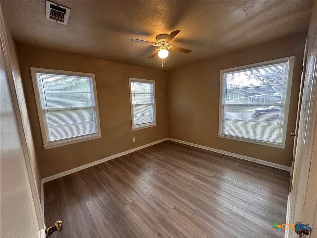505 Center Street Belton, TX 76513 - Photo 7 of 11 a view of an empty room with wooden floor and a window