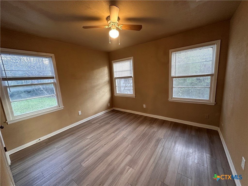 505 Center Street Belton, TX 76513 - Photo 8 of 11 a view of an empty room with wooden floor and a window