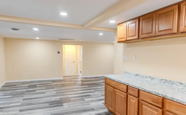 a view of kitchen with granite countertop cabinets and wooden floor