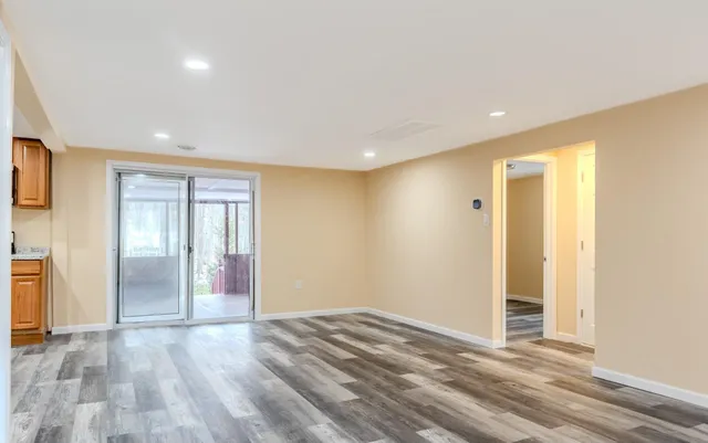 a view of empty room with wooden floor and entryway