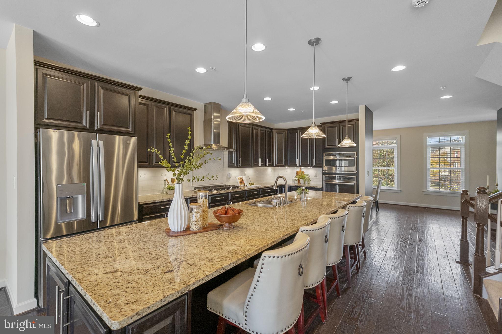 5313 Stream Bank Lane Greenbelt, MD 20770 - Photo 4 of 46 a kitchen with center island wooden floor and stainless steel appliances