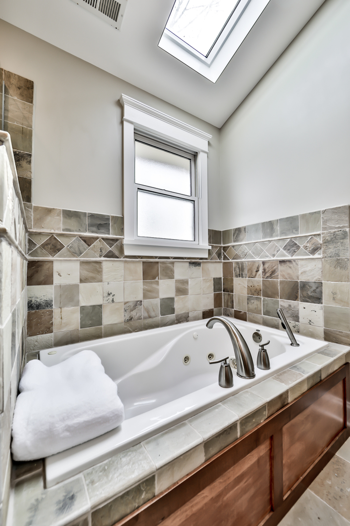 65 East Quincy Street Riverside, IL 60546 - Photo 26 of 49 a bathroom with a bathtub and next to a window