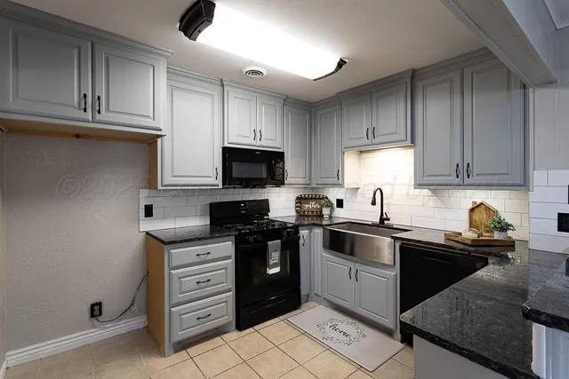 a kitchen with a sink a stove and cabinets